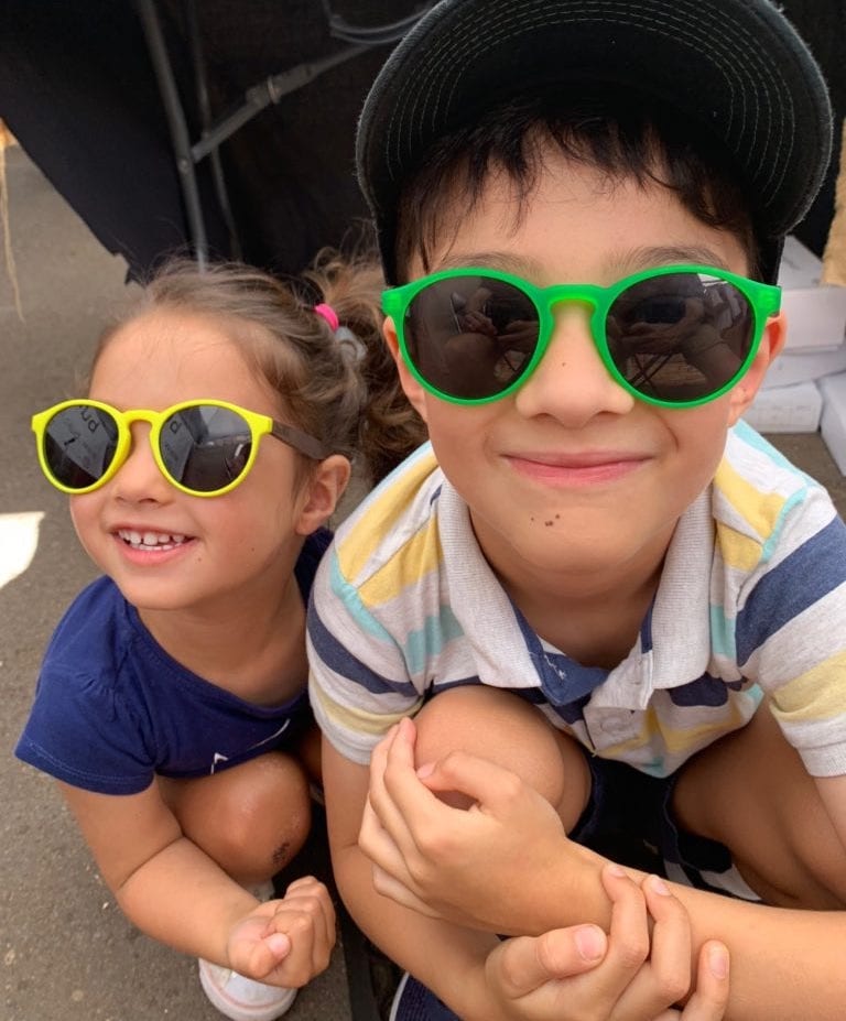boy and girl wearing yellow wooden sunglasses