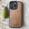 Buko natural wood iPhone case with slim black bumper on rustic timber surface with leaf