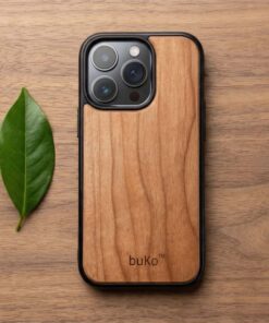 buko wooden phone case on walnut wood table with green leaf beside it