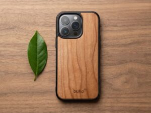 buko wooden phone case on walnut wood table with green leaf beside it