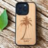 buko wooden phone case with palm tree on a rustic table next to a green leaf