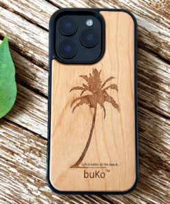 buko wooden phone case with palm tree on a rustic table next to a green leaf