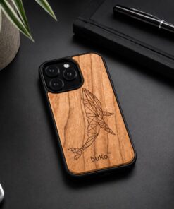 wooden phone case with a geometric whale engraving on a black minimalist desk