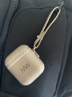 Gold leather AirPods case on black bag