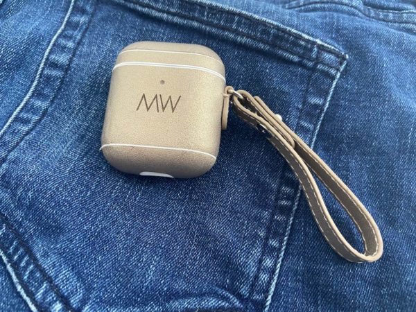 Gold leather AirPods case on blue jeans