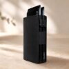 Black BuKo leather double pop-up card wallet with stacked cards on a warm neutral rustic style background.