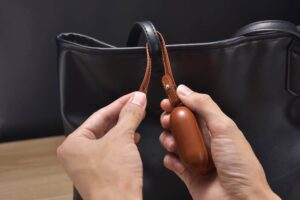 Leather Airpods 3 case attached to a bag
