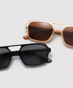 Two pairs of aviator-style sunglasses in black and transparent canary yellow frames with tinted lenses on a light grey background.