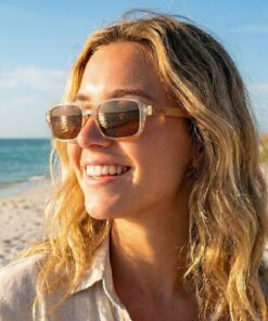a young woman wearing Frank yellow sunglasses on the beach