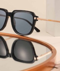 SoCal black sunglasses with gold metal arms and grey polarised lenses displayed on a mirrored surface.
