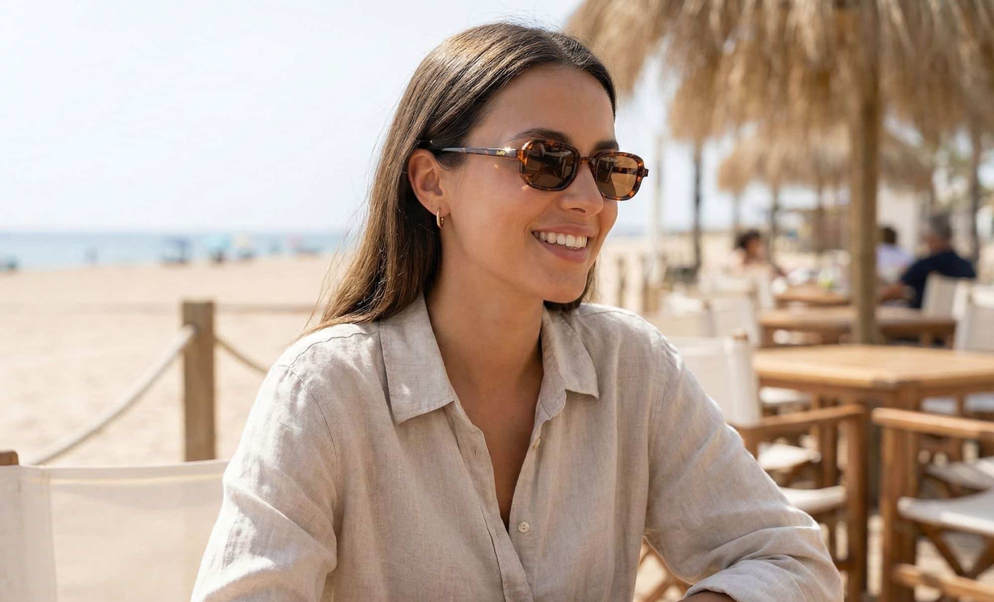 a female model wearing Catalonia sunglasses on the beach. 
