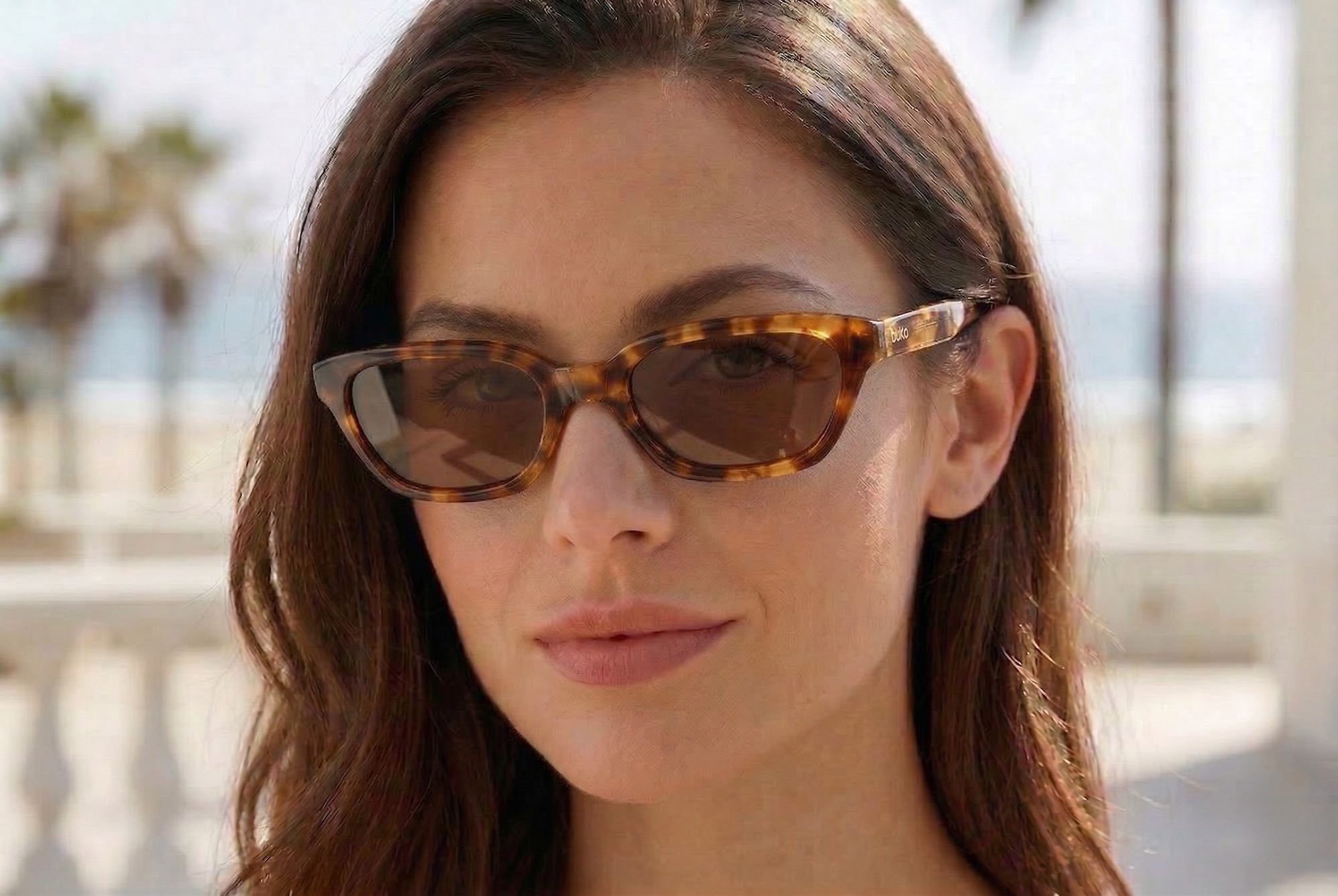 Female model wearing Monaco sunglasses by Buko in tortoiseshell acetate frame with brown polarised lenses outdoors