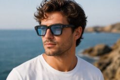 Man wearing Cove sunglasses Blackwater colour with black recycled PET frame and light blue polarised lenses by buKo at the beach