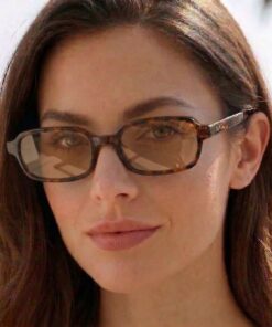 Female model wearing Cannes sunglasses by Buko with tortoiseshell frame and brown lenses at the beach in natural sunlight