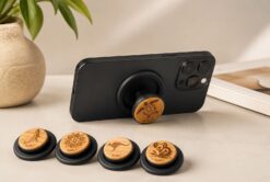 buKo MagSafe Phone Holder & Stand supporting a black iPhone with wooden turtle design and matching engraved styles displayed in front