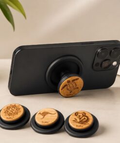 buKo MagSafe Phone Holder & Stand supporting a black iPhone with wooden turtle design and matching engraved styles displayed in front