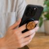 a woman holding a phone with a buko wooden phone holder and stand
