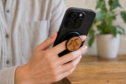 a woman holding a phone with a buko wooden phone holder and stand